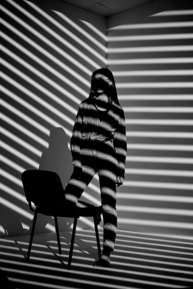 Woman standing in shadows: When fear sneaks in, it paralyses you of communicating.